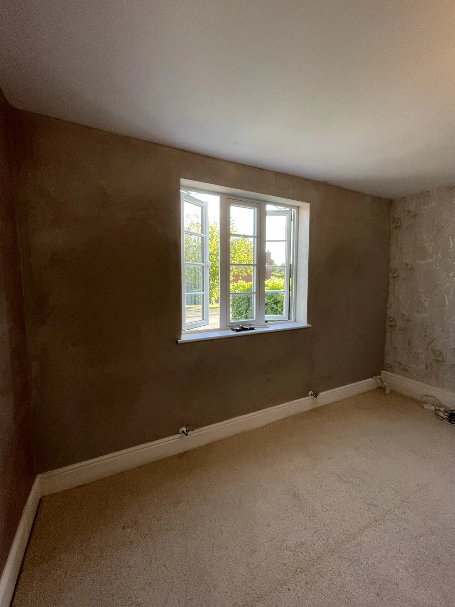 Real photo: an insulated bedroom wall plastered and ready to decorate.